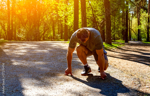 Male athlete on starting blocks looking down