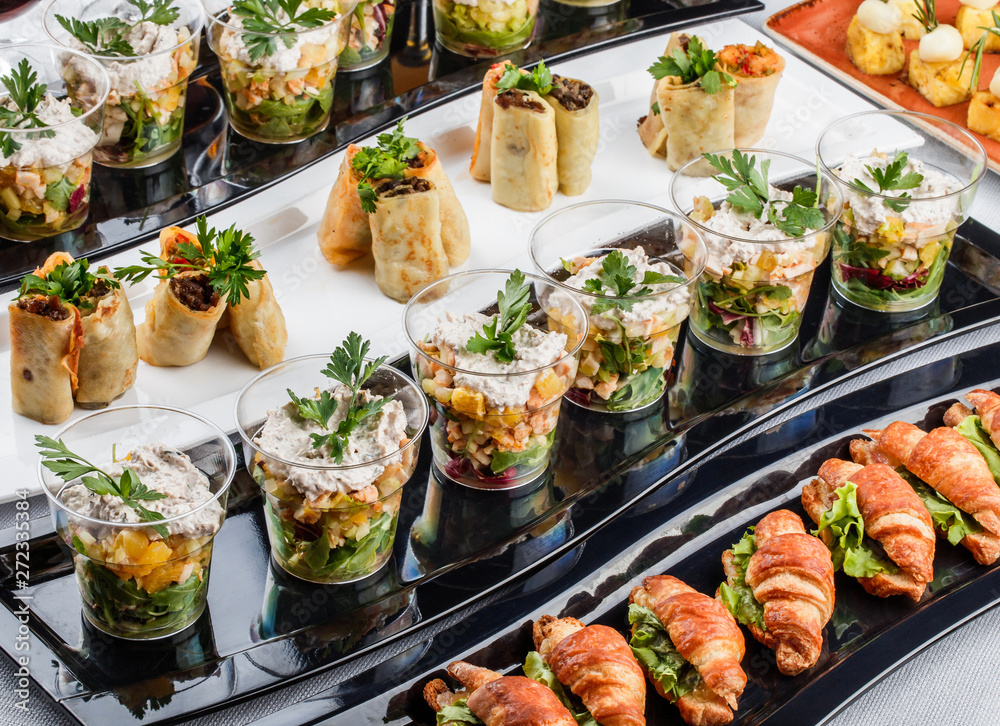 Mini appetizers with salmon fish, caviar, cheese, prawn, shrimp and greens on banquet table. Gourmet food close up, snack, antipasti, Seafood platter