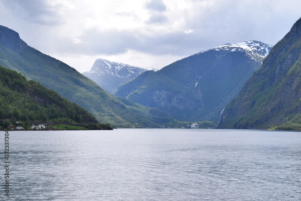 Norwegian fjord view from a Scandinavian cruise ship. Clam water with mountains and glaciers in the background