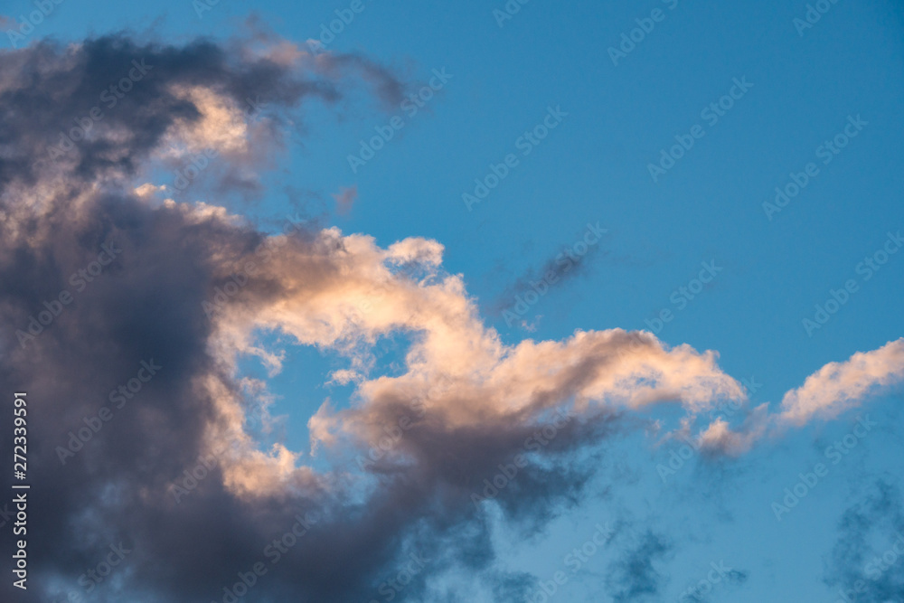 thick cloud on the blue sky lit by the setting sun light with red glow