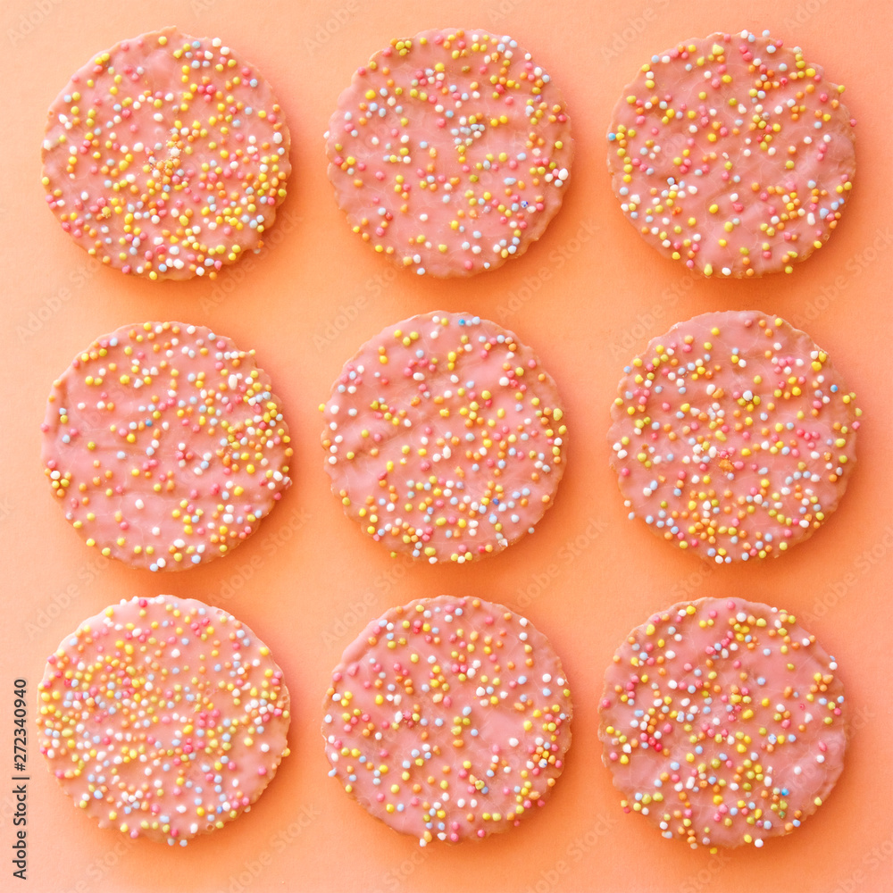 Pattern of pink biscuits with hundreds and thousands. Pattern of pink biscuits with hundreds and thousands.