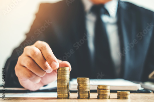Business man Accounting Calculating Cost Economic budget putting Row and coin Write Finance ,investment and saving concept photo
