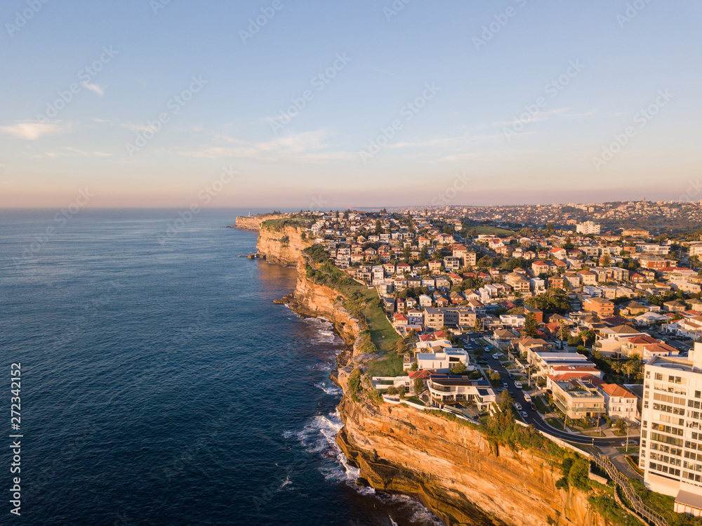 Aerial view along Sydney coastline with clear blue sky.