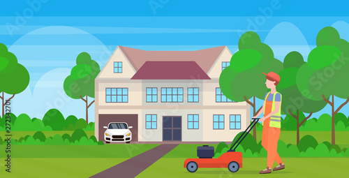 man gardener in uniform cutting grass with lawn mower gardening concept modern cottage house countryside background full length flat horizontal