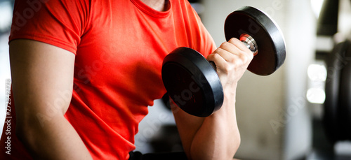 A young man from ASEAN, Asia, Europe, exercising, practicing gym with dumbbells, close-ups, men sitting on a Exercise weight bench with dumbbells and dumbbells, lifting dumbbells up and down © PAPALAH