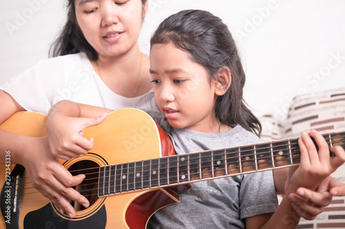 Asian little girl learning to play music.