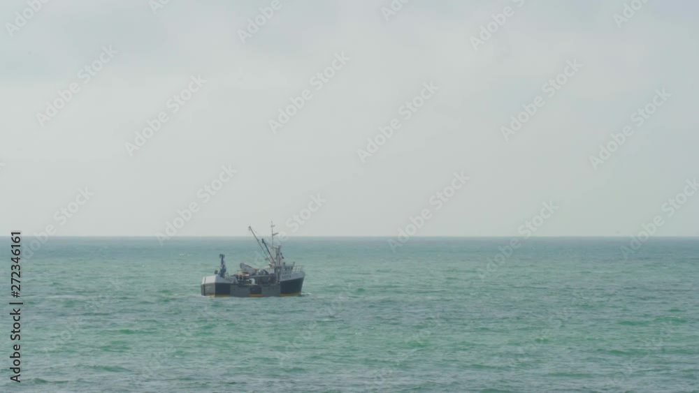 Fishing boat cruising through the bay taking its haul back to port on the blue water Fishing boat cruising through the bay taking its haul back to port on the blue water