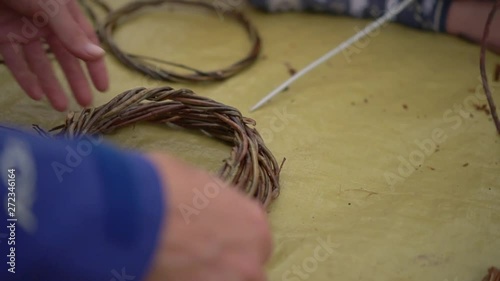 Hands, weaving a basket out of twigs photo