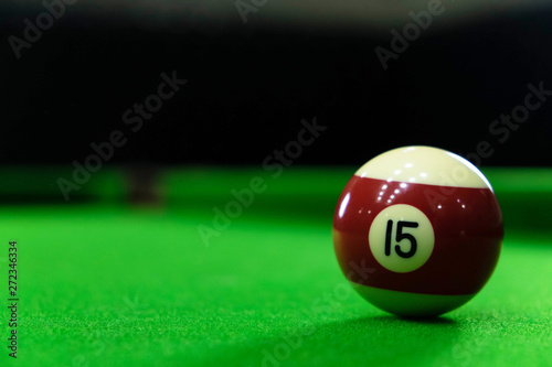 Close-up photos of billiard ball, number 15 and green floor