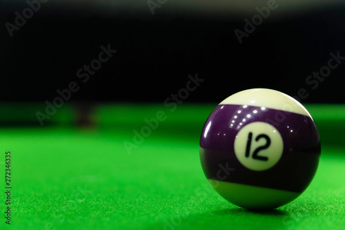 Close-up photos of billiard ball, number 12 and green floor