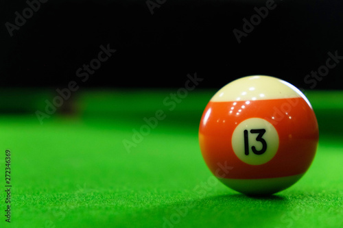 Close-up photos of billiard ball, number 13 and green floor