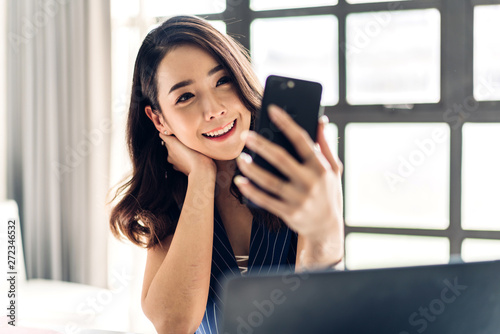 Businesswoman sitting and working with laptop computer and use smartphone.creative business people planning in her workstation at modern work loft Free Download Businesswoman sitting and working with laptop computer and use smartphone.creative business people planning in her workstation at modern work loft - GFXLoad
