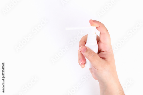 The girl is holding a throat spray in her hand on white background. Top view.