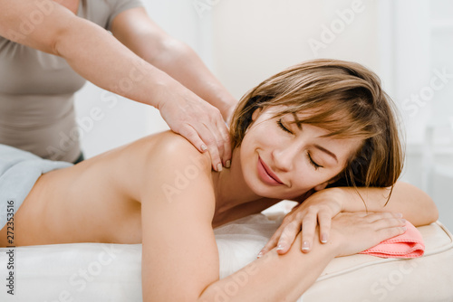 Relaxed young woman enjoying therapeutic body massage
