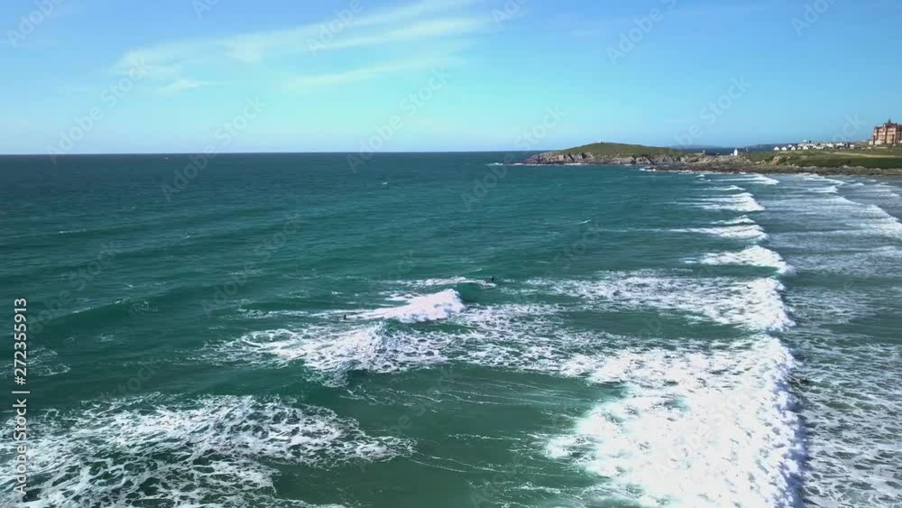 Aerial side-shot of a surfer catching a wave at Fistral beach, Newquay, Cornwall Aerial side-shot of a surfer catching a wave at Fistral beach, Newquay, Cornwall