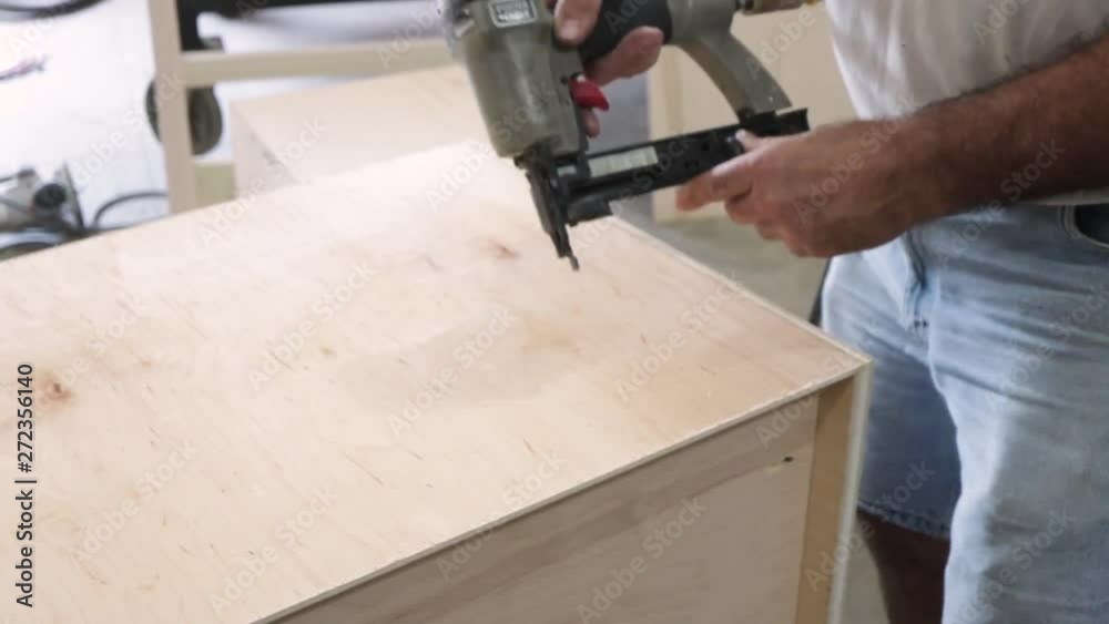 Man Nailing Cabinet Pieces Together Man Nailing Cabinet Pieces Together