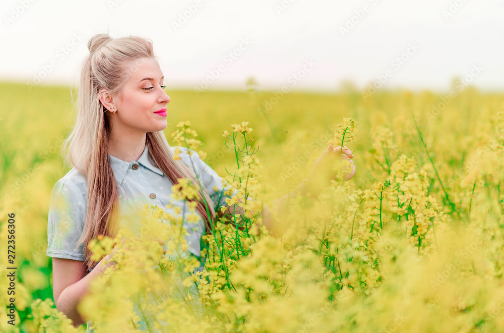 beautiful blonde girl poses for the camera in rapeseed field beautiful blonde girl poses for the camera in rapeseed field