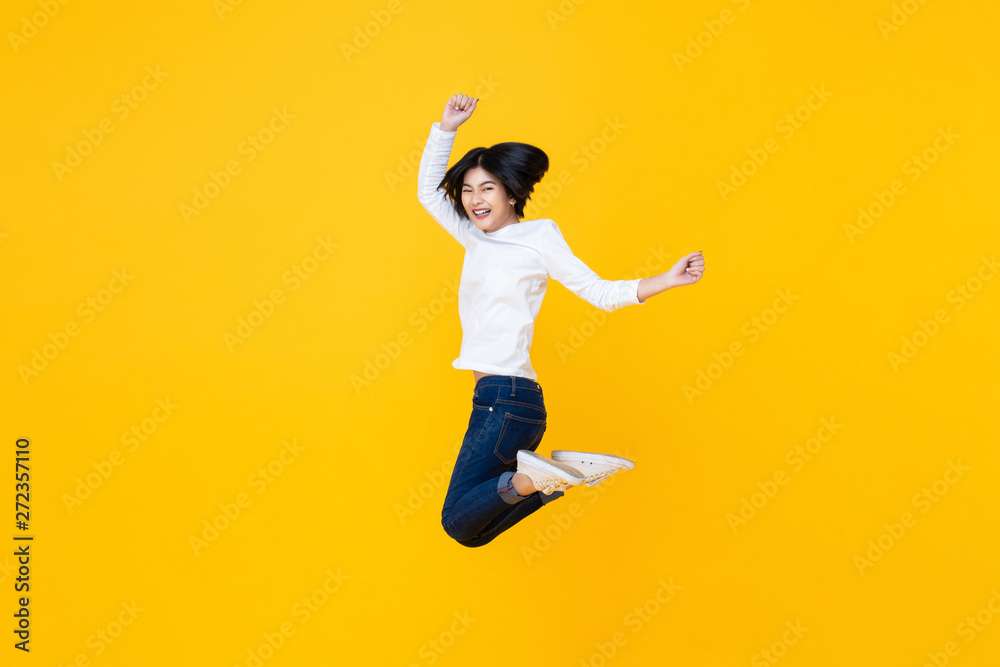 Happy energetic asian woman jumping in mid-air