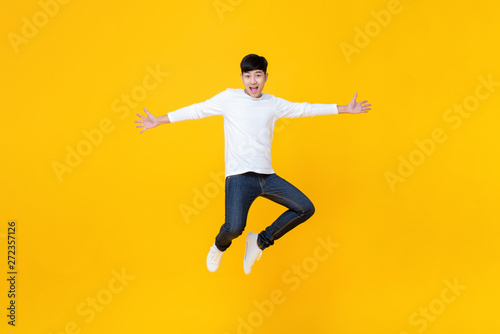 Young Asian man in casual clothes jumping