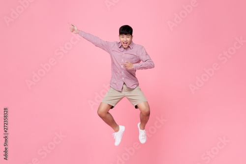 Asian man jumping with hand pointing aside
