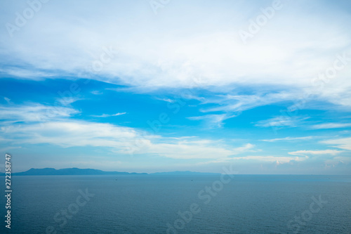 Beautiful white clouds on blue sky over calm sea with sunlight reflection