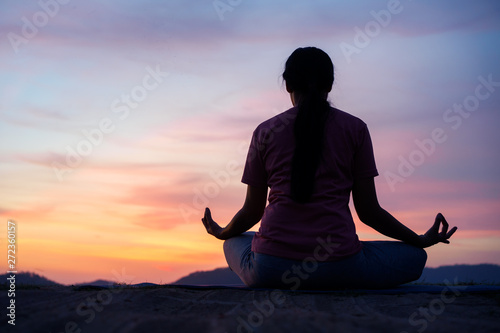 asian woman sit lotus yoga position at sunset . Practicing yoga makes meditation for healthy breathing and relaxation