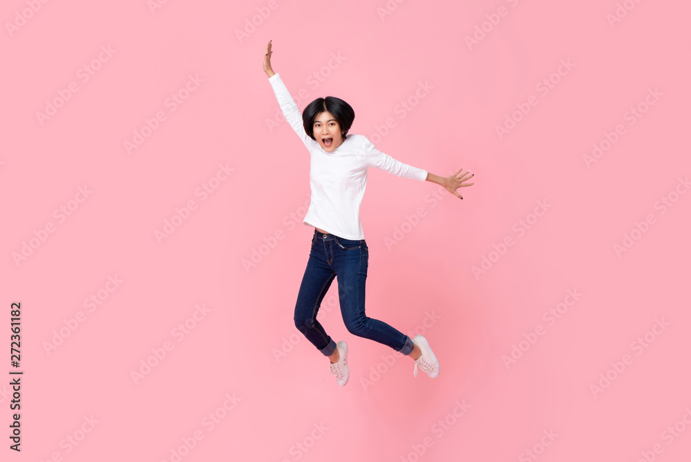 Happy energetic asian woman wearing casual clothes jumping in mid-air