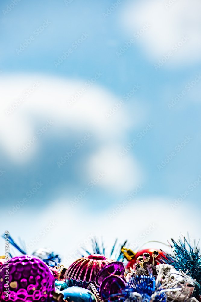 Christmas decorations on abstract background, blue sky with clouds.