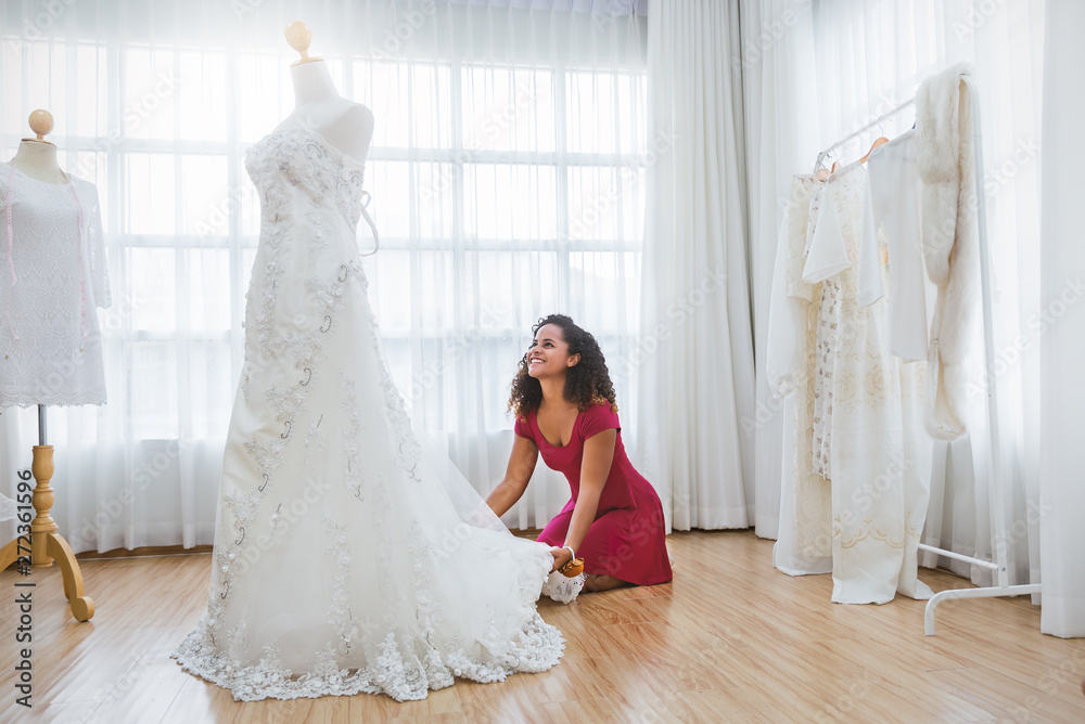 Portrait of bride preparing for the wedding. African american woman dealer consultant designer in the background of wedding dresses studio. Happiness success dream come true concept Stock Adobe Stock