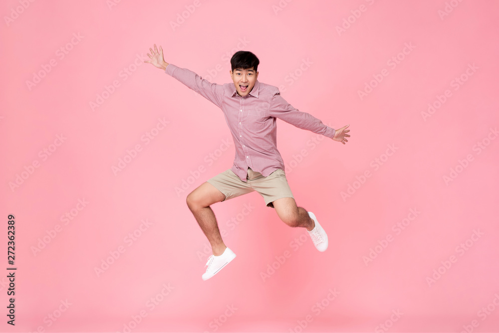 Energetic happy young Asian man jumping