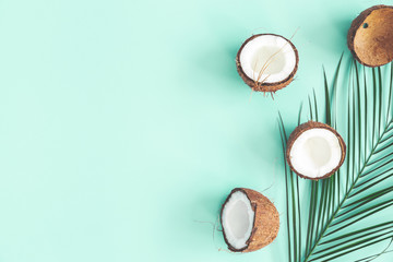 Summer composition. Coconut, palm leaf on mint background. Summer concept. Flat lay, top view, copy space