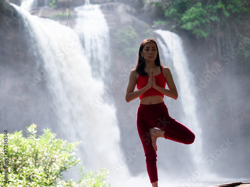 Asian woman practicing or doing yoga at the waterfall. Beautiful Landscape  Natural background  Thailand.