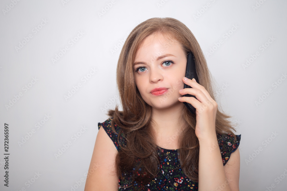 Young caucasian woman with mobile phone looks annoyed, irritated or mood Young caucasian woman with mobile phone looks annoyed, irritated or mood
