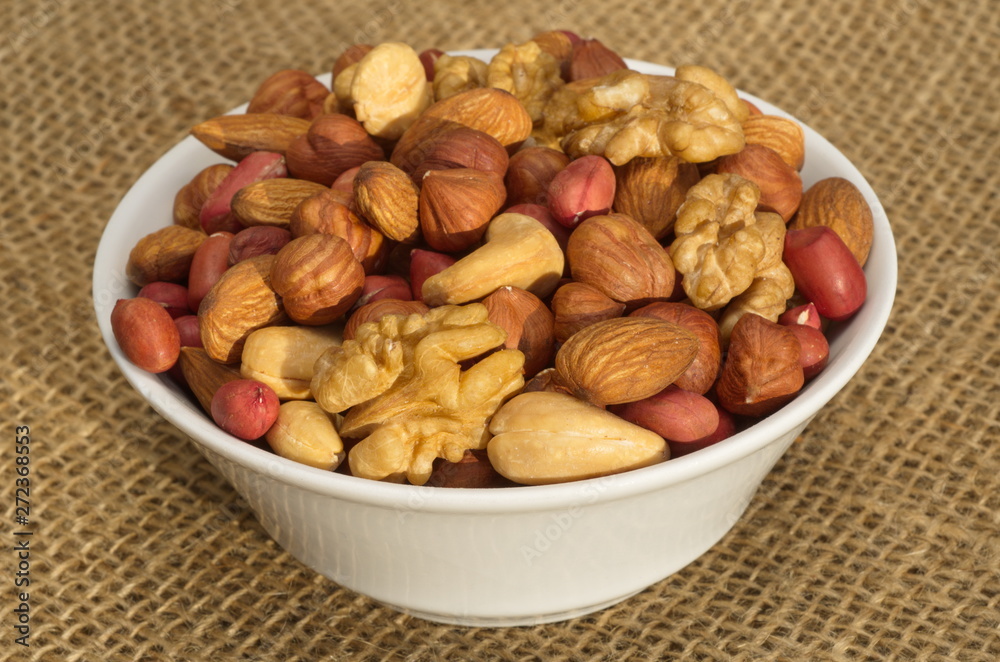 Different nuts in a bowl on burlap Different nuts in a bowl on burlap