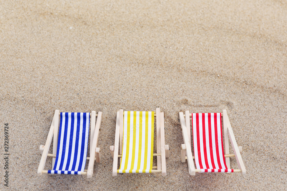three sun loungers are standing on the sand, the reverse side, the concept of summer travel three sun loungers are standing on the sand, the reverse side, the concept of summer travel