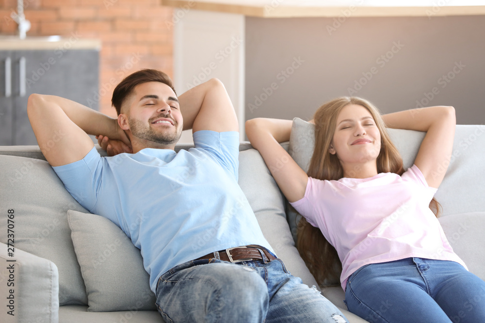 Happy young couple resting together on sofa at home Happy young couple resting together on sofa at home