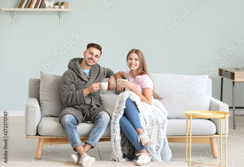 Happy young couple resting together on sofa at home