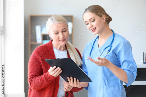 Medical assistant explaining mature woman her diagnosis in clinic