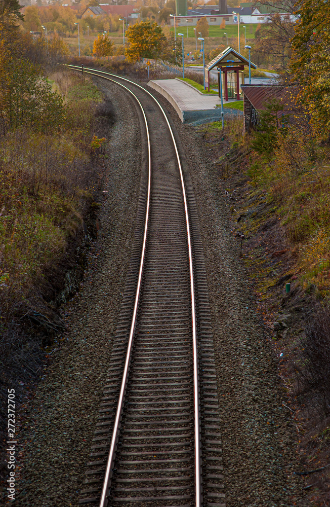 Fototapeta premium Curved railway tracks with at small station.