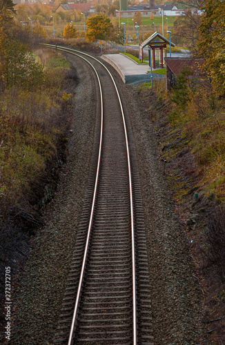 Curved railway tracks with at small station.