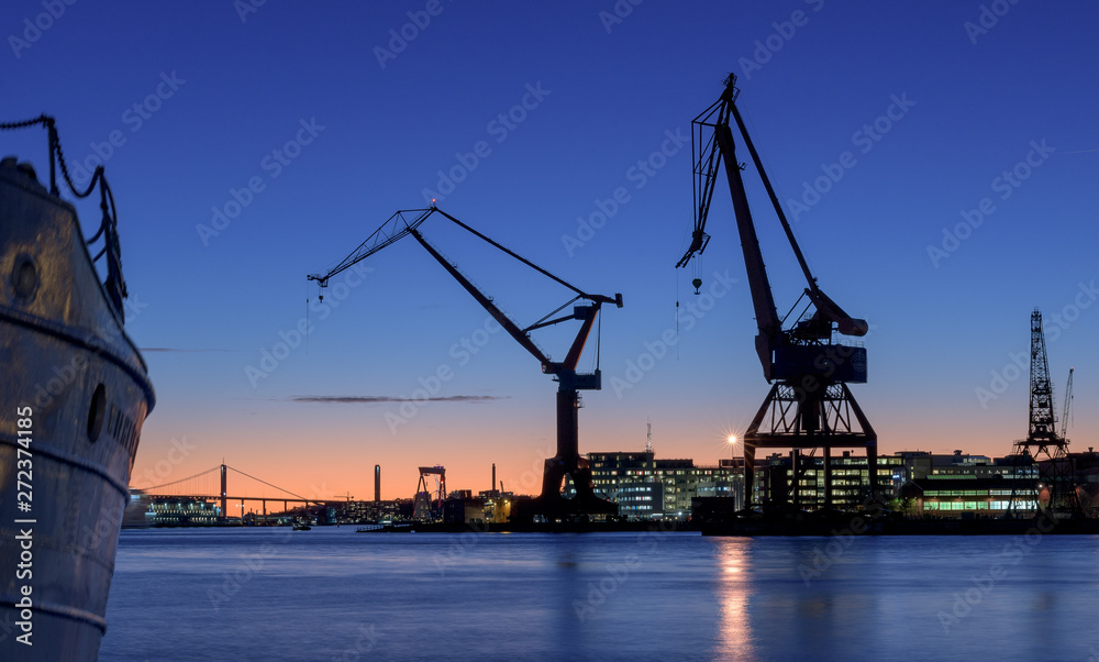 cranes of and old wharf in a beautiful sunset.