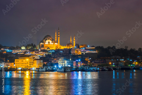 Night view of Istanbul cityscape  Suleymaniye Mosque  Rustem Pasha Mosque  with floating tourist boats in Bosphorus  Istanbul Turkey
