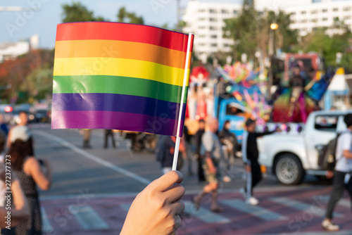LGBT pride month background. a spectator waves a gay rainbow flag at LGBT gay pride parade festival in Thailand