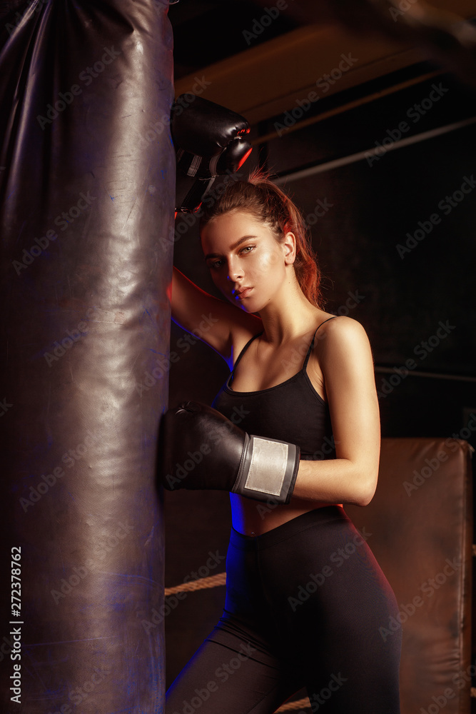 Portrait of young sports woman in black tracksuit