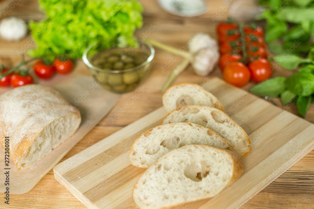 Sliced bread, ciabatta on wooden background. Preparation for the preparation of bruschetta. Sliced bread, ciabatta on wooden background. Preparation for the preparation of bruschetta.