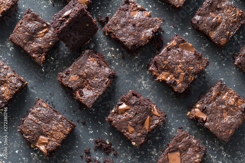 Chocolate brownie squares on black mottled background - baked chocolate brownies
