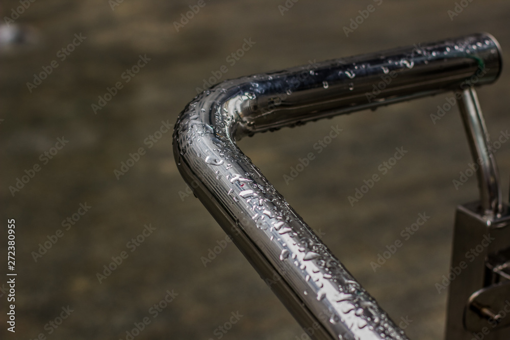 plumbing concept photography of wet metal pipe with water drops on surface and dark blurred unfocused background plumbing concept photography of wet metal pipe with water drops on surface and dark blurred unfocused background