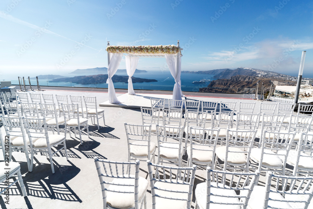 Obraz premium Beautifully arranged place for a wedding ceremony on the Greek coast. Romantic vacation by the sea