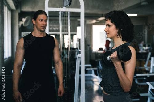 Fitness woman with personal trainer at gym.