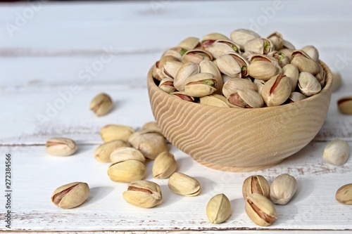 Bowl with pistachios on wooden background. Top view with copy space photo